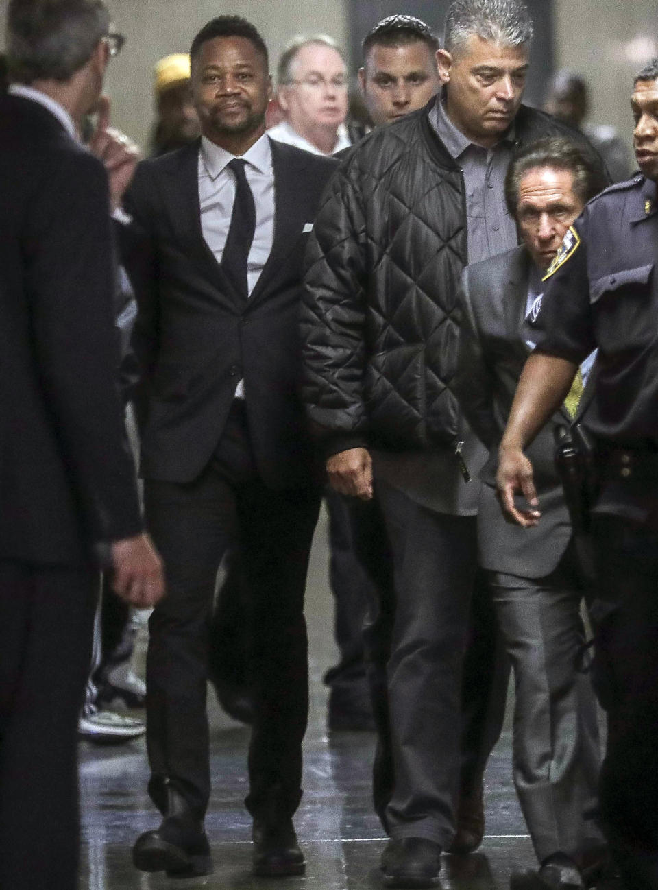 Cuba Gooding Jr., second from left, is escorted handcuffed as he arrives in court to face sexual misconduct charges, Tuesday Oct. 15, 2019, in New York. Gooding Jr. pleaded not guilty to an indictment alleging two instances of sexual misconduct. The new charge involves an alleged incident in October 2018. The defense paints it as a shakedown attempt. (AP Photo/Bebeto Matthews)