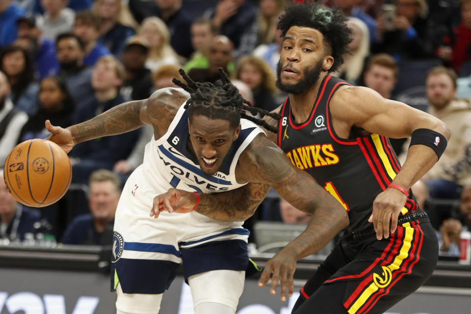 Minnesota Timberwolves forward Taurean Prince (12) dribbles around Atlanta Hawks forward Saddiq Bey, right, in the first quarter of an NBA basketball game Wednesday, March 22, 2023, in Minneapolis. (AP Photo/Bruce Kluckhohn)