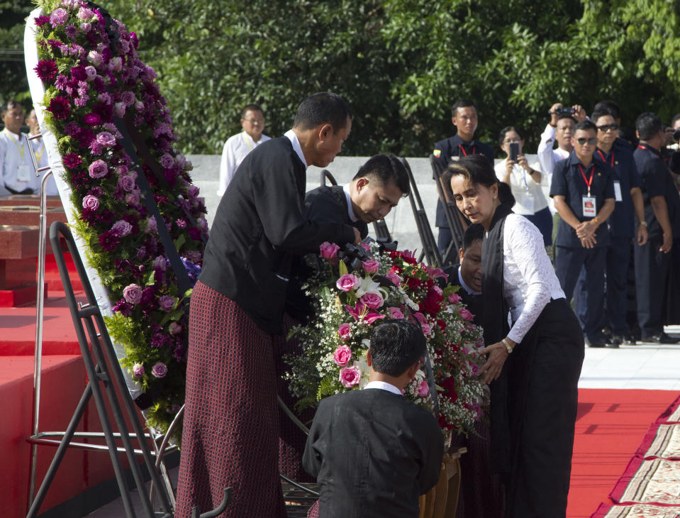 Myanmar leader Aung San Suu Kyi, right, lays flower basket at the tomb of her late father and Myanmar's independence hero Gen. Aung San during a ceremony to mark the 72nd anniversary of his 1947 assassination, at the Martyrs' Mausoleum Friday, July 19, 2019, in Yangon, Myanmar. The country's Independence hero Gen. Aung San and his cabinet were gunned down in 1947. (AP Photo/Thein Zaw)