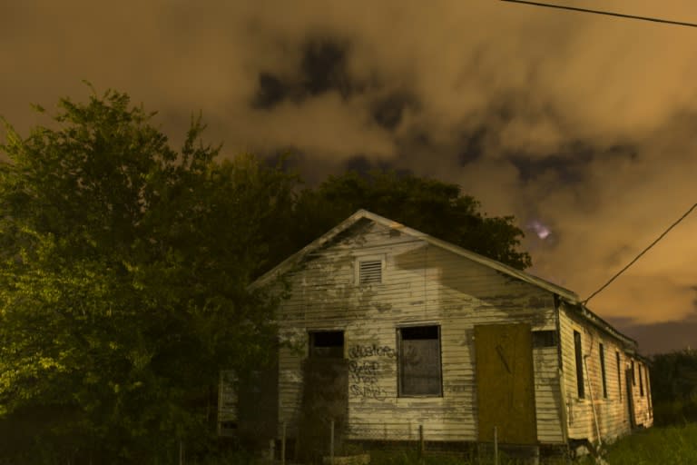 An abandoned house, damaged by Hurricane Katrina, in the eerie glow of streetlamps is seen in the lower Ninth Ward of New Orleans on August 15, 2015