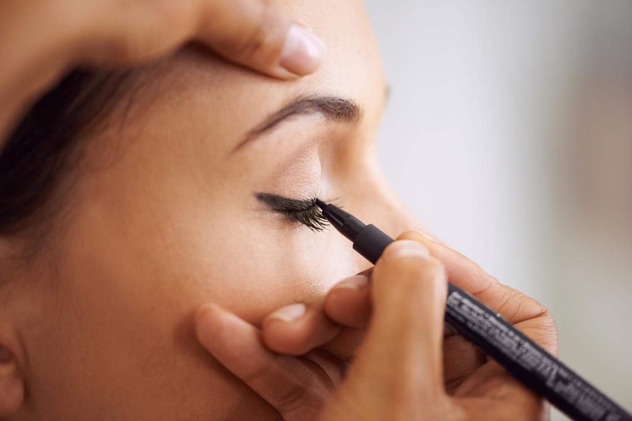 Closeup of a young woman getting liner applied to her eyes