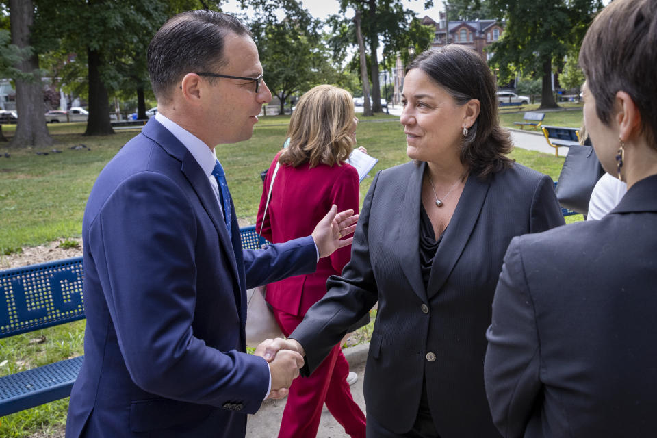 Pennsylvania Attorney General Josh Shapiro, left, greets, Jacqueline C. Romero, United States Attorney for the Eastern District of Pennsylvania before press conference at Malcolm X Park, Wednesday morning. July 27, 2022, West Philadelphia, Pa. Trident Mortgage Co., a division of Warren Buffett's Berkshire's HomeServices of America, discriminated against potential Black and Latino homebuyers in Philadelphia, New Jersey and Delaware, the Department of Justice said Wednesday, in what they are calling the second-largest redlining settlement in history. (Alejandro A. Alvarez/The Philadelphia Inquirer via AP)