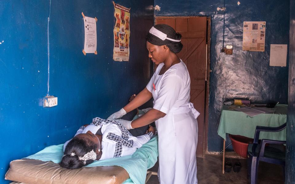 A midwife performs an antenatal check for Mercy Yakubu at the Primary Health Care Centre in Akwanaga, Nasarawa State, Nigeria - Nelson Owoicho/Gates Archive