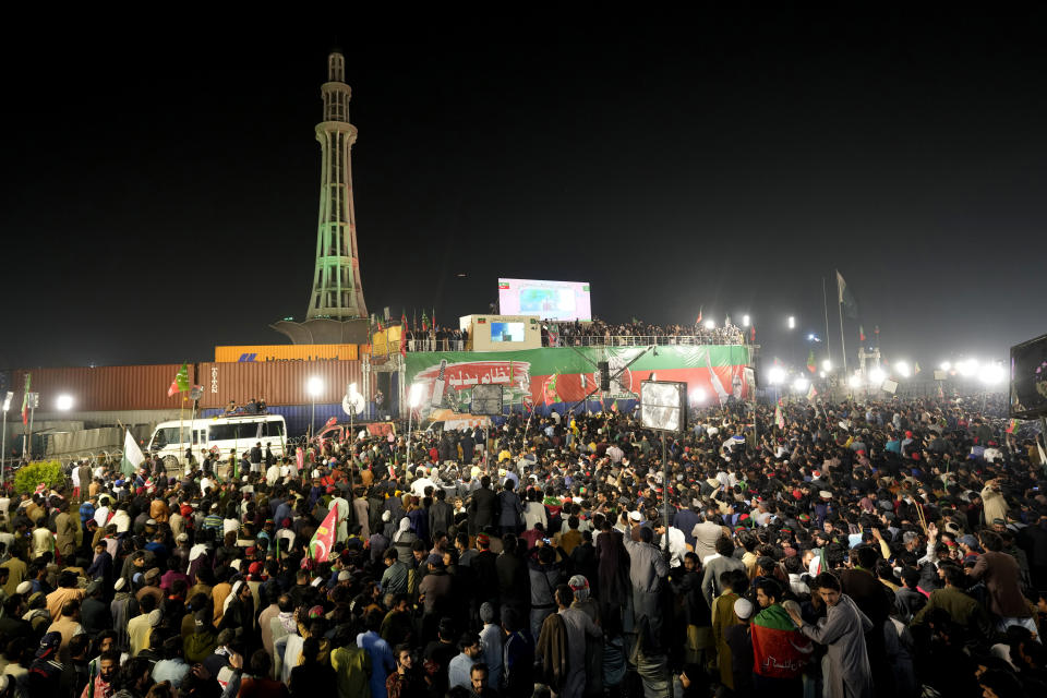 Supporters of former Prime Minister Imran Khan listen to his speech during a rally, with the Minar-e-Pakistan (Tower of Pakistan) seen in the background, in Lahore, Pakistan, Sunday, March 26, 2023, to pressure the government of Shahbaz Sharif to agree to hold snap elections. (AP Photo/K.M. Chaudary)