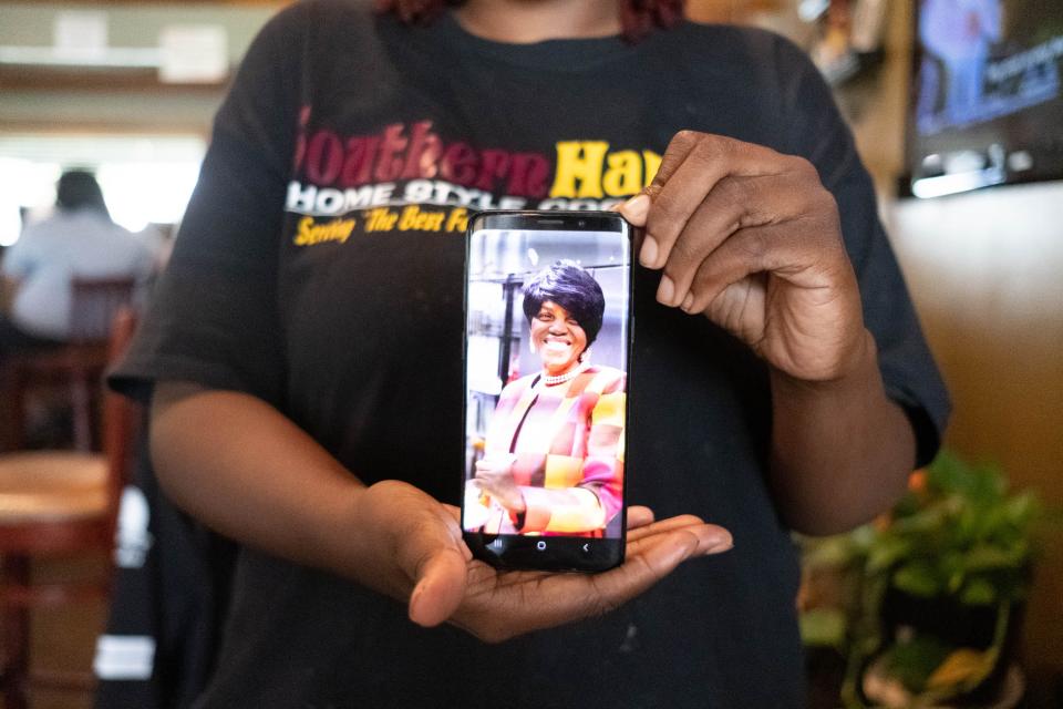 Nina Brown holds a cellphone  displaying a photo of her mother, Betty Baskin, inside Southern Hands Home Style Cooking on Sept. 20, 2019. Baskin died in May 2018.