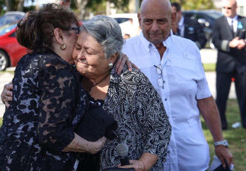 Las asistentes de vuelo Mercy Ruiz, a la izquierda, y Beverly Raposa, se abrazan tras inaugurar el monumento conmemorativo ante la mirada del sobreviviente Ron Infantino,