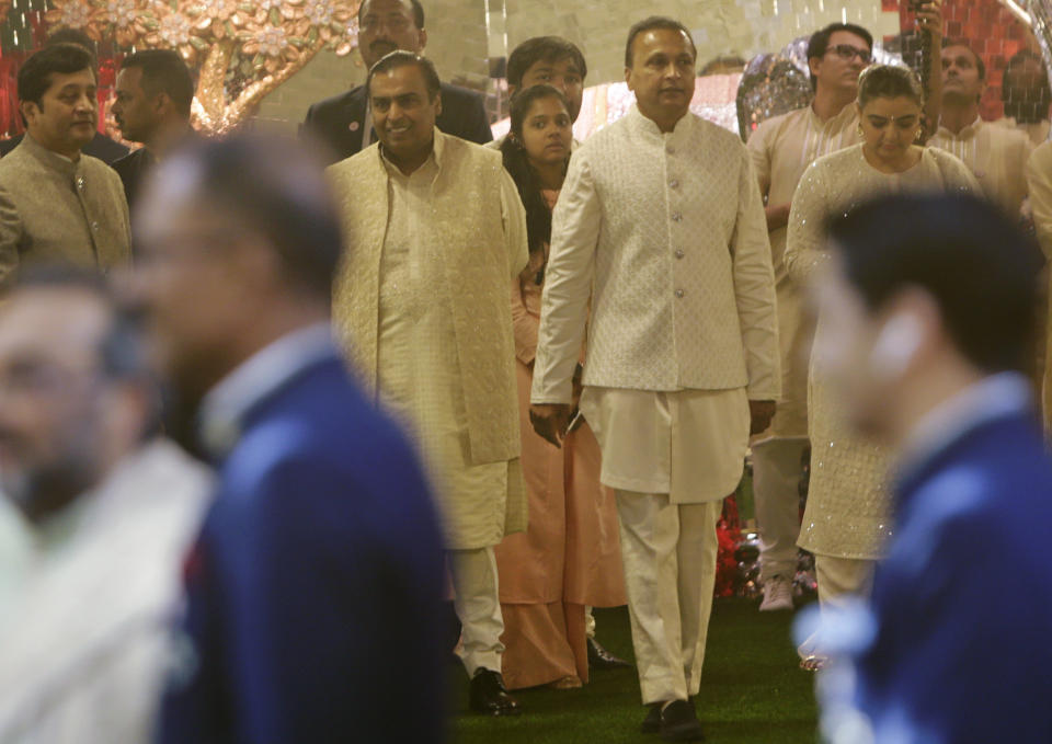 Reliance Industries Chairman Mukesh Ambani, center left, walks with his brother Anil Ambani during the wedding of his daughter Isha in Mumbai, India, Wednesday, Dec. 12, 2018. In a season of big Indian weddings, the Wednesday marriage of the scions of two billionaire families might be the biggest of them all. Isha is the Ivy League-educated daughter of industrialist Mukesh Ambani, thought to be India's richest man. The groom, Anand Piramal is the son of industrialist Ajay Piramal, thought to be worth $10 billion. (AP Photo/Rajanish Kakade)