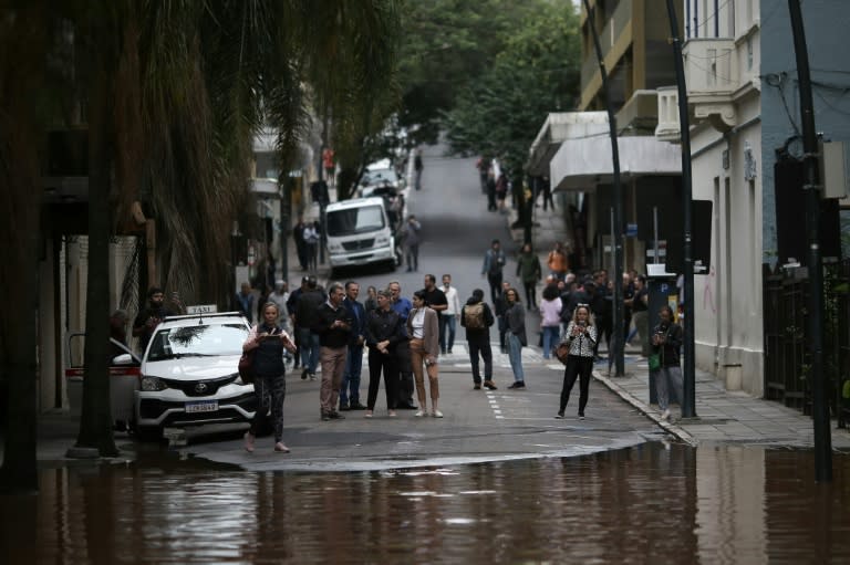 Un grupo de gente observa una calle inundada en el centro histórico de Porto Alegre, estado de Rio Grande do Sul, Brasil, el 3 de mayo de 2024 (Anselmo Cunha)