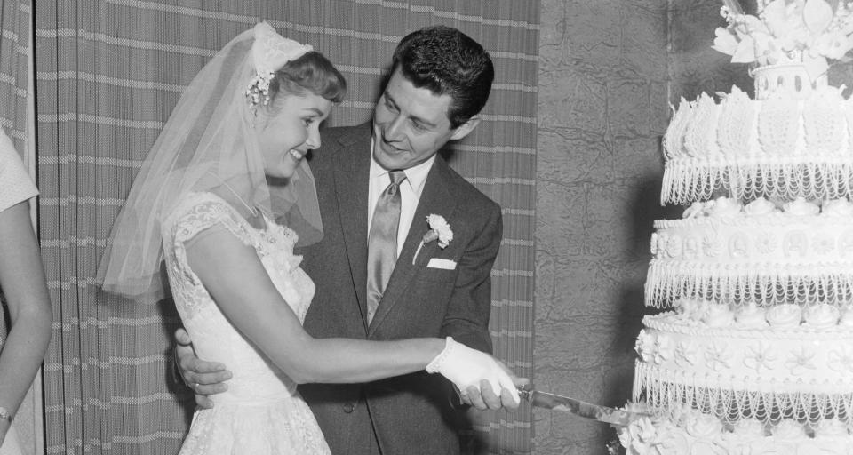 Debbie Reynolds and Eddie Fisher cut the wedding cake following their nuptials in 1955 in the Catskills. Their 15-month romance was climaxed by a three-minute civil ceremony. (Photo: Getty Images)