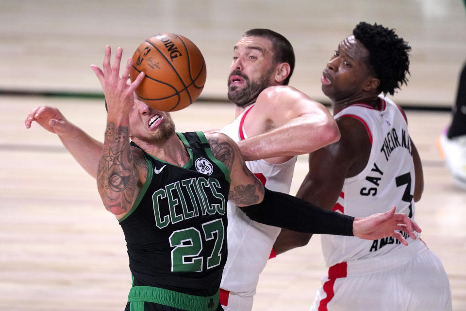 Boston Celtics' Daniel Theis (27) competes for a rebound with Toronto Raptors' Marc Gasol, center, and OG Anunoby (3) during the second half of an NBA conference semifinal playoff basketball game Friday, Sept. 11, 2020, in Lake Buena Vista, Fla. (AP Photo/Mark J. Terrill)