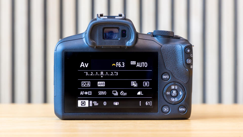 Canon EOS R100 camera on a table with a striped background