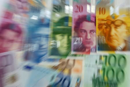 FILE PHOTO: Various Euro banknotes lay next to various Swiss Franc notes in this picture illustration at a bank in Warsaw