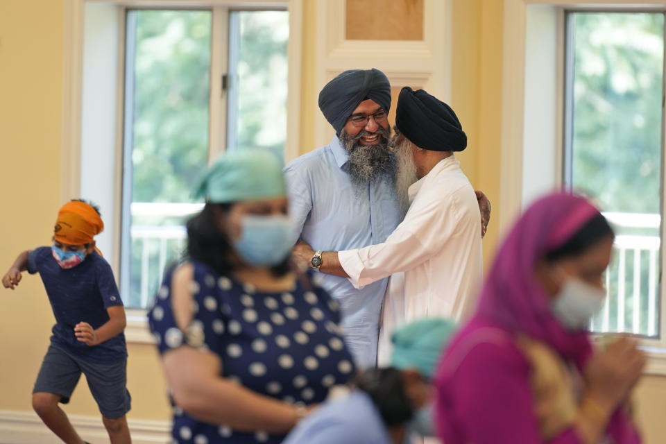 Raghuvinder Singh, center left, greets a friend after a Sikh worship service at a gurdwara in Glen Rock, N.J., Sunday, Aug. 15, 2021. Baba Punjab Singh, a Sikh priest visiting from India, was shot in the head by a white supremacist Army veteran in Wisconsin in 2012, and left partially paralyzed. He died from his wounds in 2020. Over seven years, the priest’s son, Raghuvinder Singh, split his time between caring for his father in Oak Creek and working in Glen Rock, New Jersey, as assistant priest at a gurdwara there. Raghuvinder said the greatest lesson his father taught him was how to embody “chardi kala,” which calls for steadfast optimism in the face of oppression. (AP Photo/Seth Wenig)