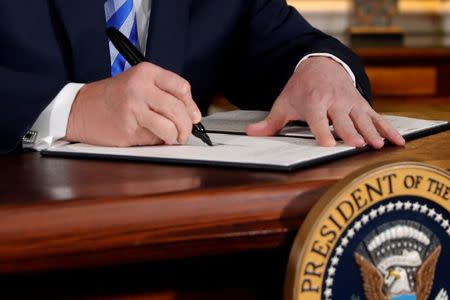U.S. President Donald Trump signs a proclamation declaring his intention to withdraw from the JCPOA Iran nuclear agreement in the Diplomatic Room at the White House in Washington, U.S. May 8, 2018. REUTERS/Jonathan Ernst/Files