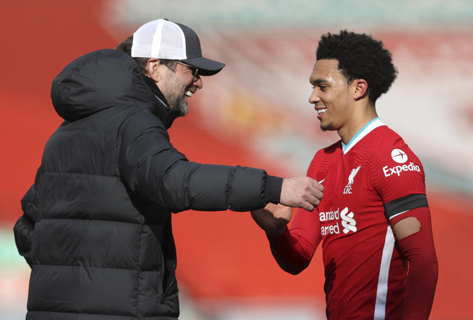 Liverpool's manager Jurgen Klopp greets Trent Alexander-Arnold at the end of the English Premier League soccer match between Liverpool and Aston Villa at Anfield stadium in Liverpool, England, Saturday, April 10, 2021. (Clive Brunskill/Pool via AP)