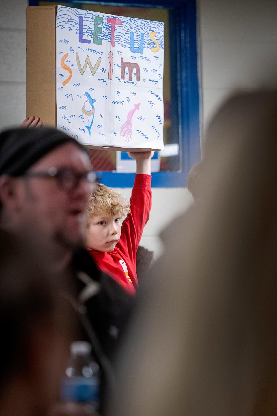 Iverson Smith, 8, holds a sign reading “let us swim,” as community members demand answers for the Malvern Hills Pool closure, February 21, 2024.
