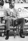 While nursing a foot injury, Michael Jordan sits on the bench while watching his Chicago Bulls play the New York Knicks in Chicago, on Dec. 26, 1985. (AP Photo/Fred Jewell)