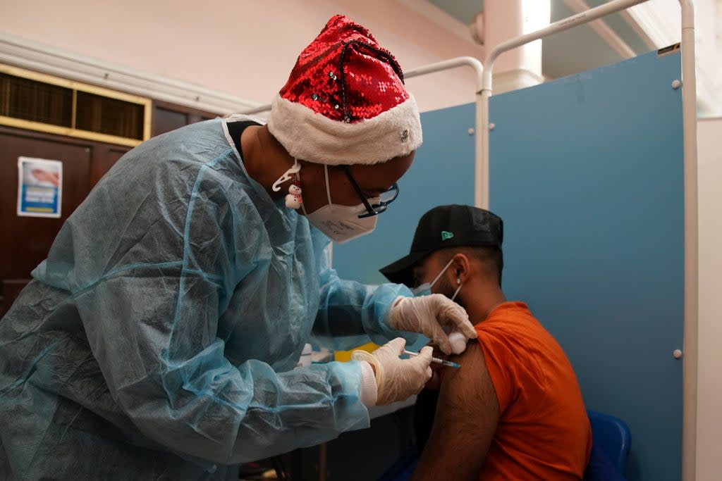 A vaccinator administers a ‘Jingle Jab’ Covid vaccination booster injection at Redbridge Town Hall, in Ilford, Essex, as the coronavirus booster programme continues (Gareth Fuller/PA) (PA Wire)