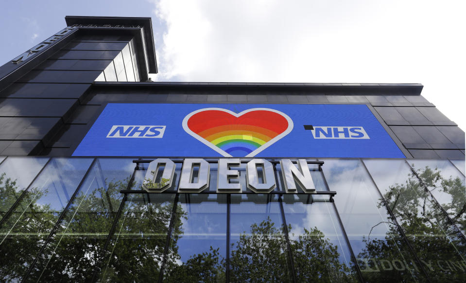 A sign to thank the NHS is displayed as trees are reflected on the Leicester Square Odeon cinema in London, Monday, May 4, 2020, as the UK enters a seventh week of lockdown to help stop the spread of coronavirus. The highly contagious COVID-19 coronavirus has impacted on nations around the globe, many imposing self isolation and exercising social distancing when people move from their homes. (AP Photo/Kirsty Wigglesworth)