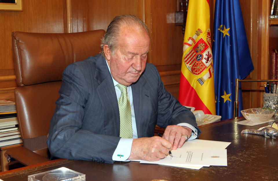 El rey Juan Carlos I firmando su abdicación al trono frente al presidente del gobierno español Mariano Rajoy en el histórico momento del 2 de julio de 2014, en el palacio de la Zarzuela en Madrid, España. (Getty Images)