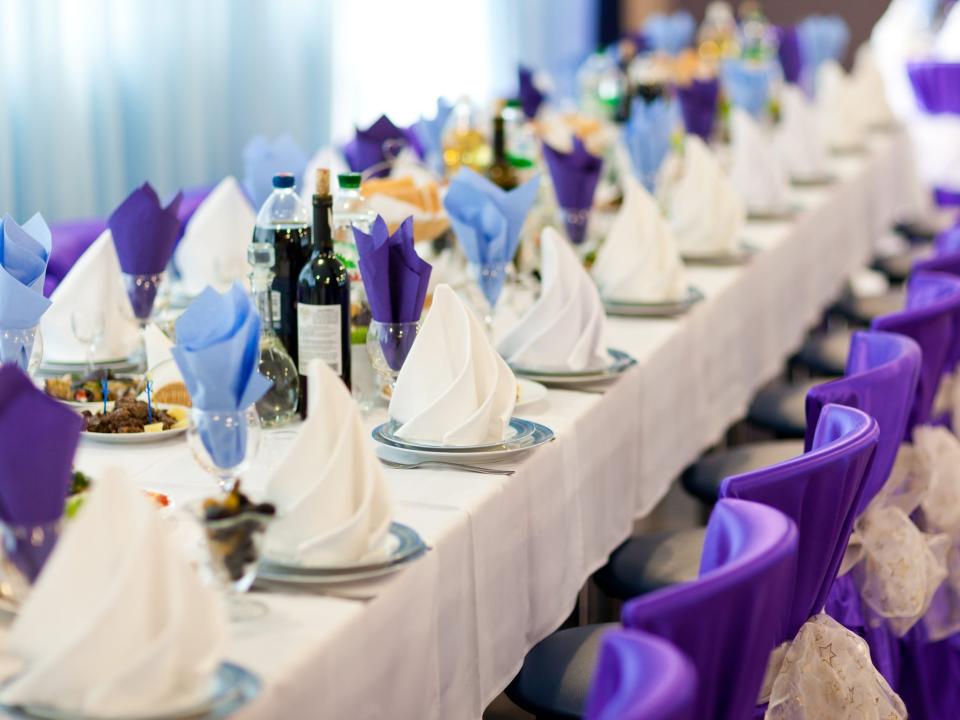 Wedding table setting with blue and purple napkins and purple seats