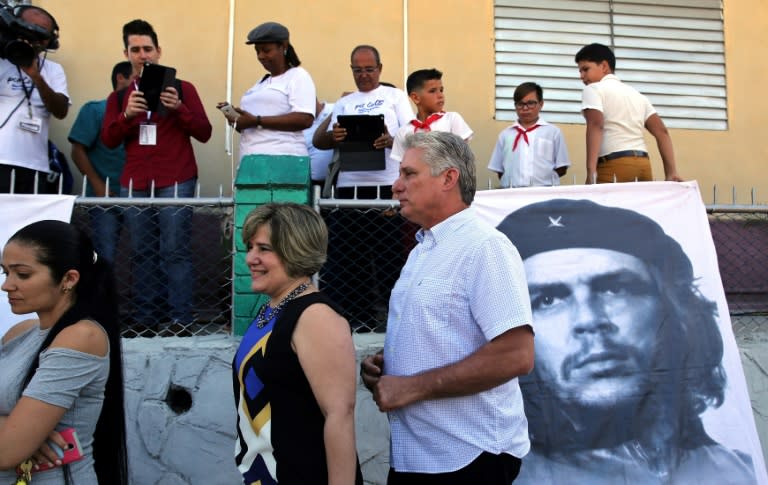 Cubans, including First Vice President Miguel Diaz-Canel (R) and his wife Lis Cuesta (L) stand in line to vote on a new National Assembly that will choose the country's next president