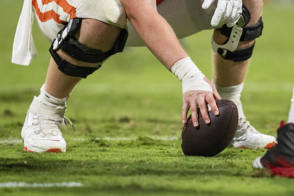 Clemson offensive lineman Will Putnam gets ready to snap the ball during an NCAA college football game against Florida Atlantic on Sept. 16, 2023, in Clemson, S.C. Most of the grass fields in top level of Division I are in the South, Southwest and California. (AP Photo/Jacob Kupferman)