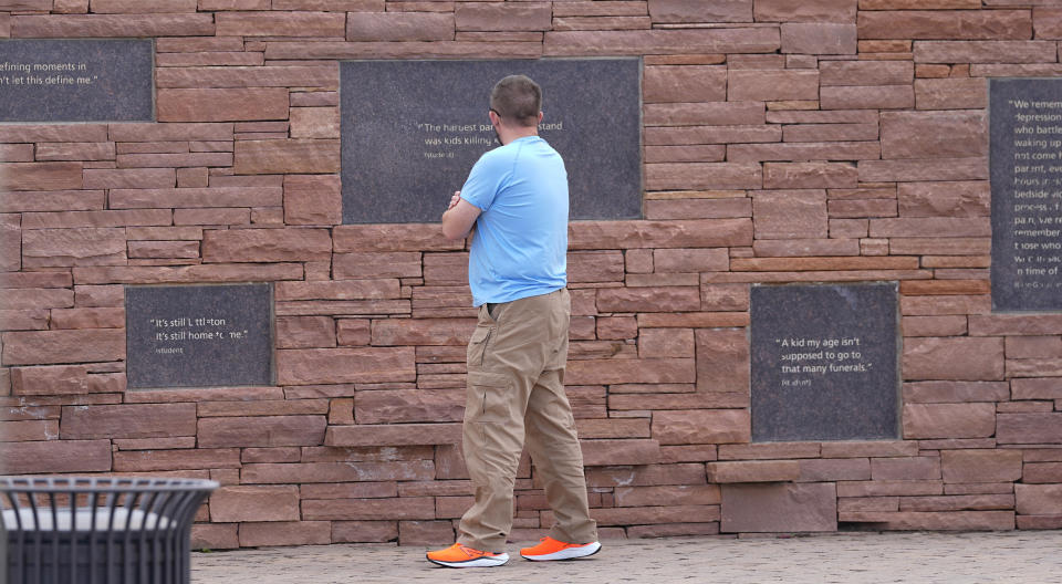 A visitor looks at the plaques on the wall of healing at the Columbine Memorial, Wednesday, April 17, 2024, in Littleton, Colo. Trauma still shadows the survivors of the horrific Columbine High School shooting as the attack's 25th anniversary approaches. (AP Photo/David Zalubowski)