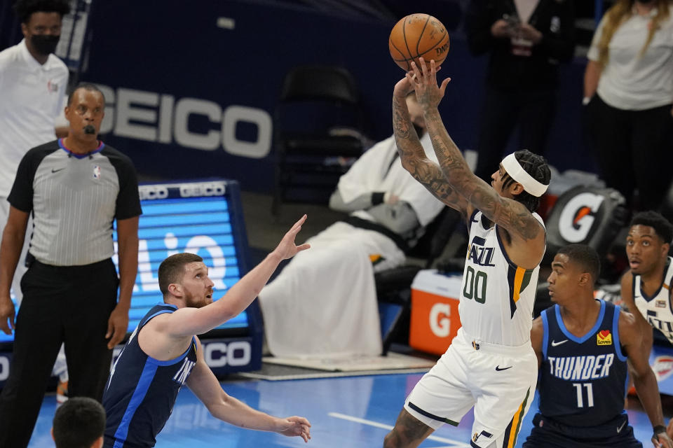 Utah Jazz guard Jordan Clarkson (00) shoots over Oklahoma City Thunder guard Svi Mykhailiuk, left, in the second half of an NBA basketball game Friday, May 14, 2021, in Oklahoma City. (AP Photo/Sue Ogrocki)