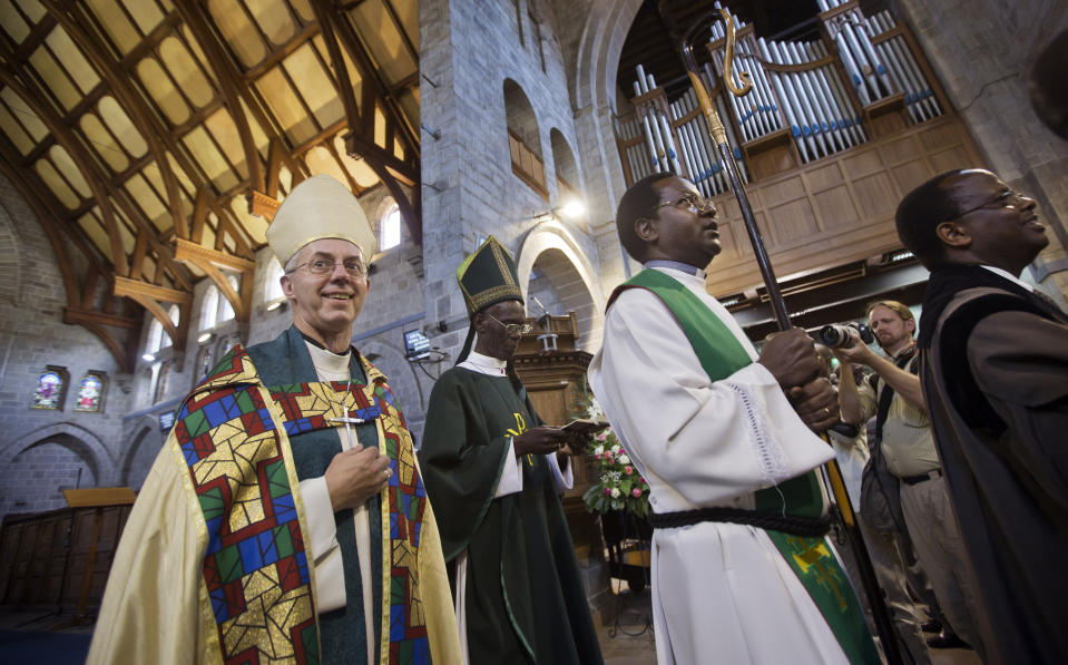 FILE - The Archbishop of Canterbury Justin Welby, left, accompanied by Archbishop of Kenya Eliud Wabukala, center left, leaves after conducting a service at the All Saints Cathedral in Nairobi, Kenya Sunday, Oct. 20, 2013. Welby made the one-day visit to Kenya to meet with the Primates of the Anglican Communion on the eve of the second Global Anglican Future Conference (GAFCON) in Nairobi. In 2022, conservative bishops – notably from Africa and Asia – have affirmed their opposition to LGBTQ inclusion. (AP Photo/Ben Curtis, File)