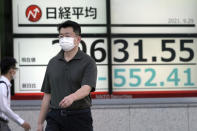 A man wearing a protective mask walks in front of an electronic stock board showing Japan's Nikkei 225 index at a securities firm Wednesday, Sept. 29, 2021, in Tokyo. Asian shares fell sharply on Wednesday after a broad slide on Wall Street as investors reacted to a surge in U.S. government bond yields. (AP Photo/Eugene Hoshiko)