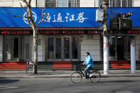 A cyclist rides past a branch of Haitong Securities, in Shanghai, China, January 26, 2017. REUTERS/Aly Song