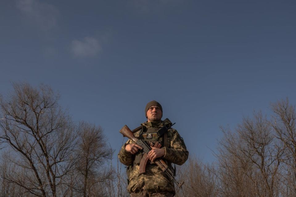 A Ukrainian serviceman stands guard checking for Russian drones in the sky as a soldier in a tractor digs a trench system in the Zaporizhzhia region in January (AFP via Getty Images)