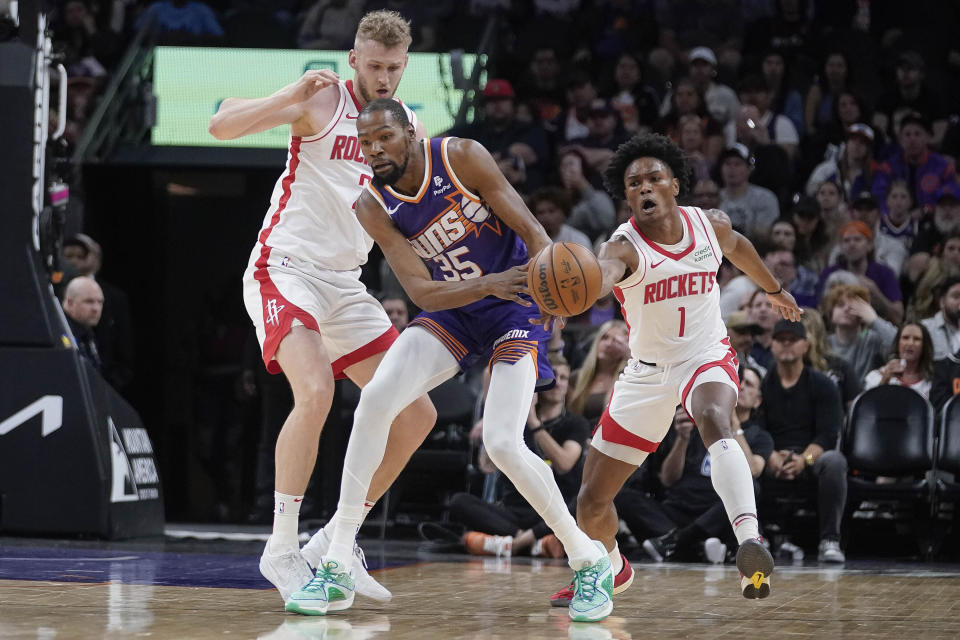 Phoenix Suns forward Kevin Durant (35) gets double-teamed by Houston Rockets center Jock Landale, left, and forward Amen Thompson (1) during the first half of an NBA basketball game in Phoenix, Saturday, March. 2, 2024. (AP Photo/Darryl Webb)
