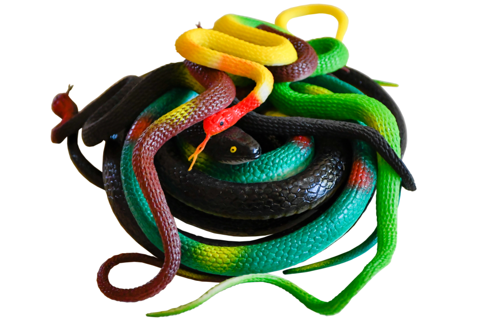 A pile of rubber snakes, topped with a bright yellow one with a red head