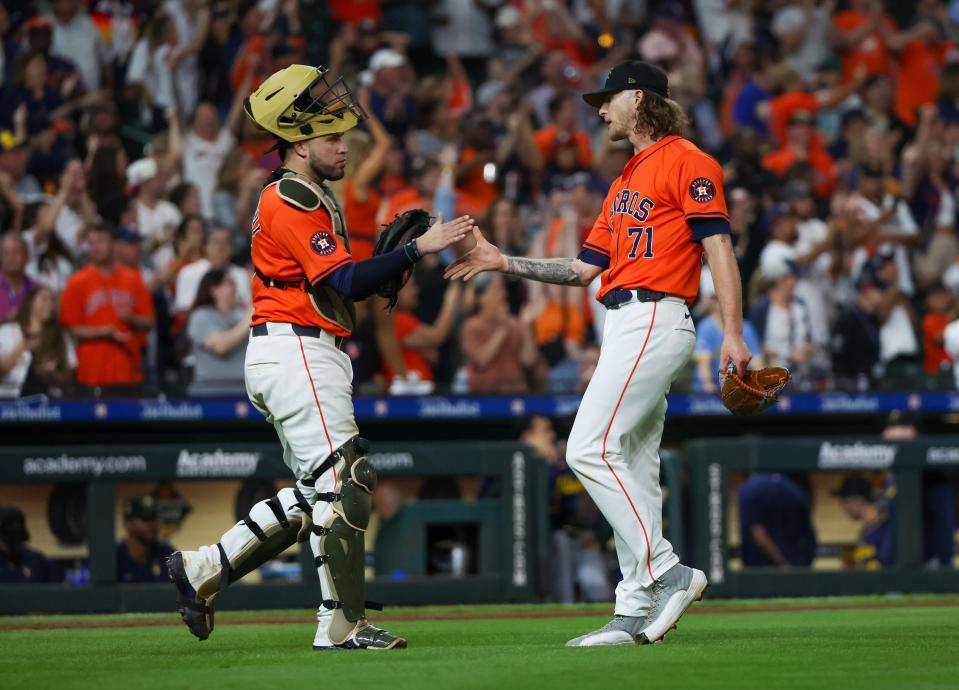 Astros catcher Victor Caratini, left, and relief pitcher Josh Hader celebrate the win against the Brewers at Minute Maid Park on Friday night.