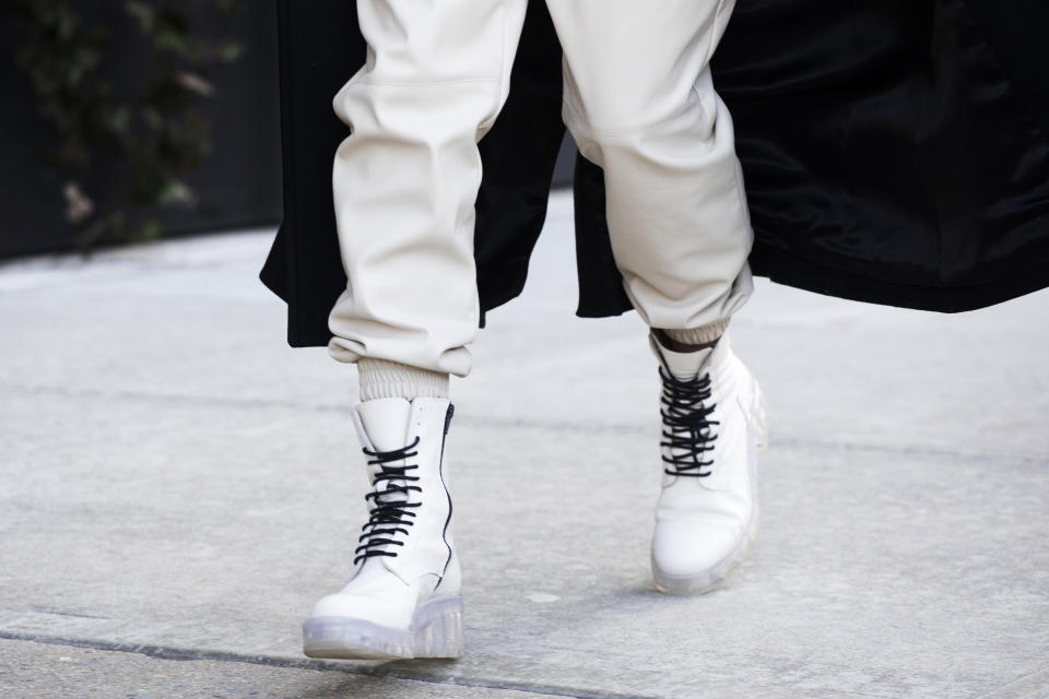 A model walks in laced white boots while arriving for a show during Fashion Week, Wednesday, Feb. 12, 2020 in New York. (AP Photo/Mark Lennihan)