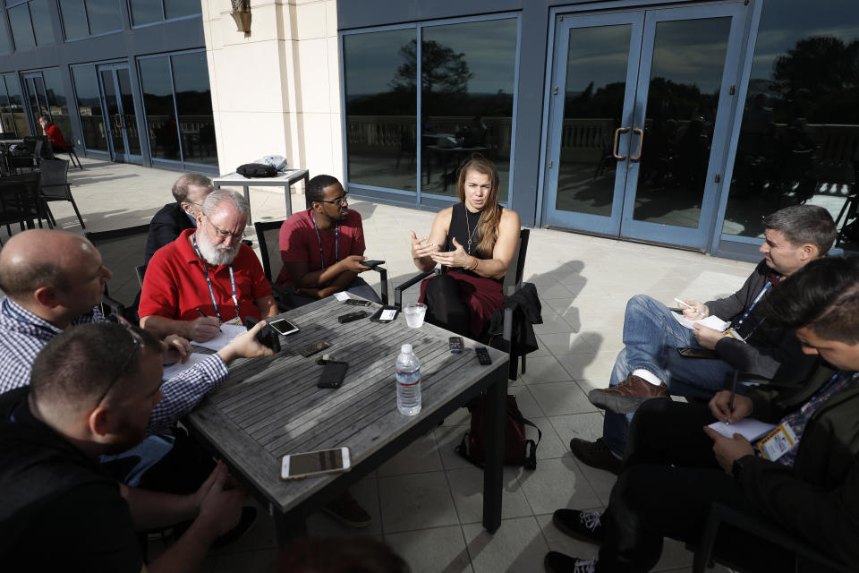 New York Yankees minor league hitting coach Rachel Balkovec, center, speaks to reporters at the Major League Baseball winter meetings Tuesday, Dec. 10, 2019, in San Diego. Balkovec is believed to be the first woman hired as a full-time hitting coach by a major league organization. (AP Photo/Gregory Bull)