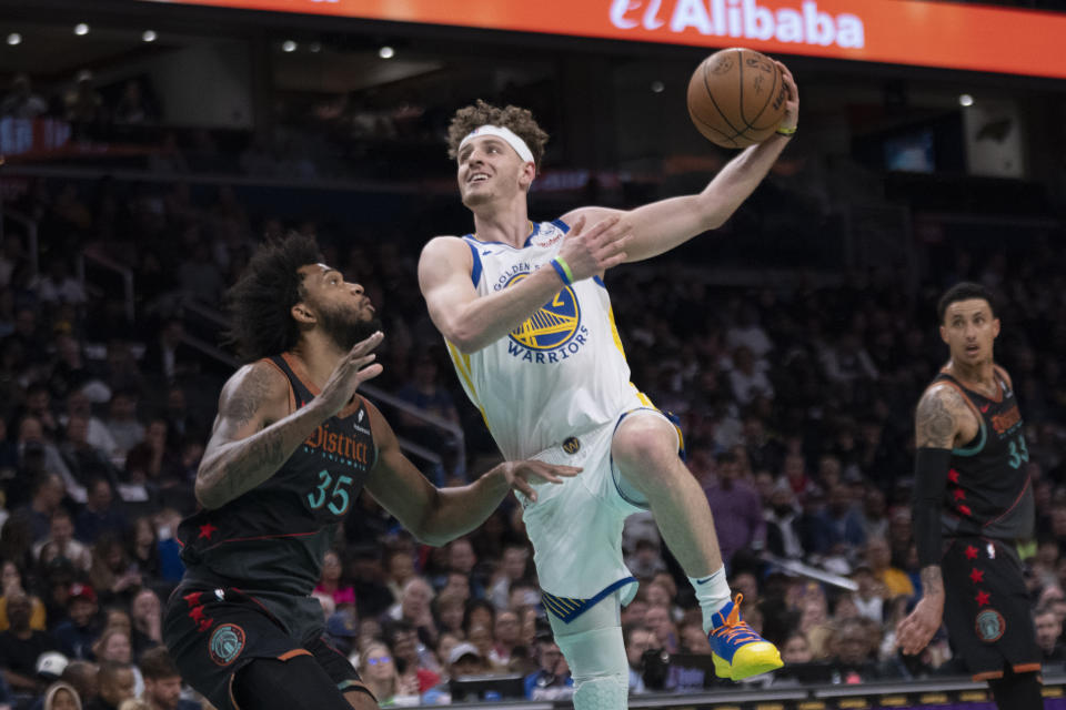 Golden State Warriors guard Brandin Podziemski (2) shoots while Washington Wizards forward Marvin Bagley III (35) defends during the first half of an NBA basketball game in Washington, Tuesday, Feb. 27, 2024. (AP Photo/Manuel Balce Ceneta)