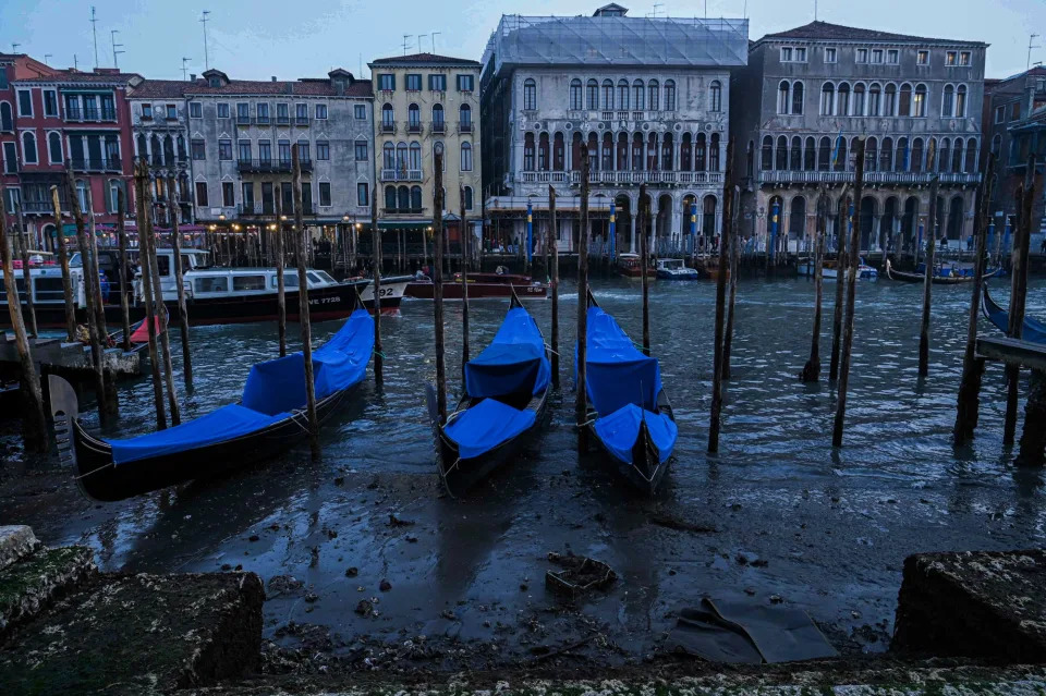 This photograph taken on February 20, 2023, shows gondolas tied up in Venice Canal Grande, during a severe low tide in the lagoon city of Venice.