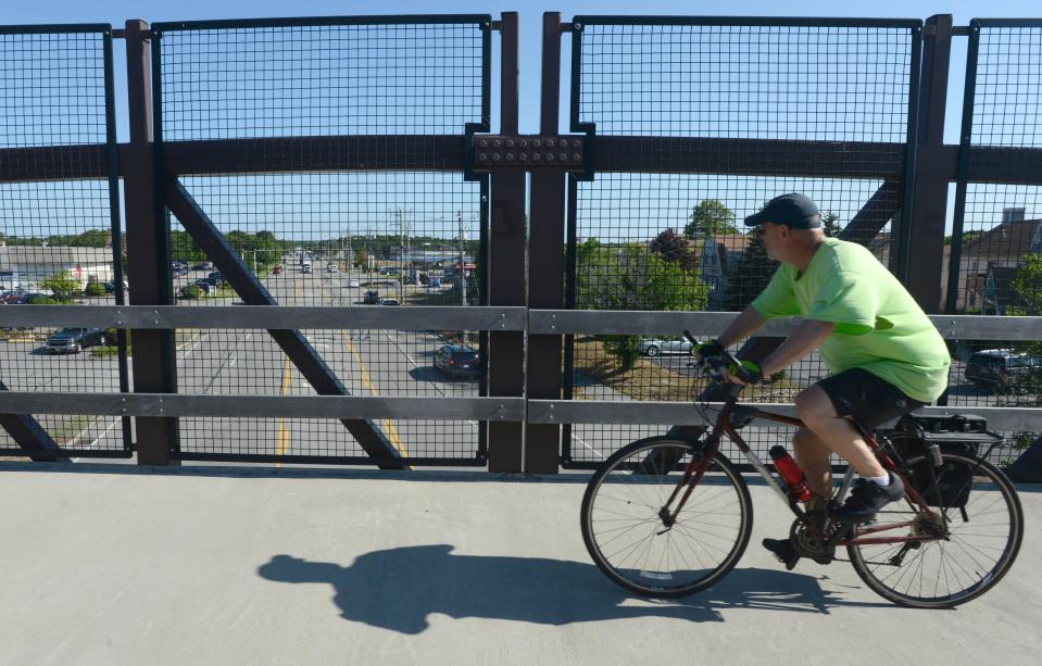 Bicyclists cross over Route 134 in South Dennis on the Cape Cod Rail Trail overpass that was built to improve safety along the popular cycling route.