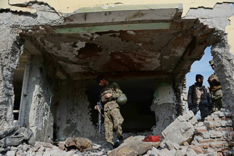 Afghan security personnel inspect a building used by insurgents to launch an attack on the Pakistan consulate in Jalalabad