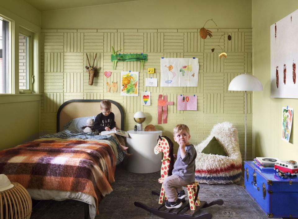 a couple of kids sitting on a bed in a room