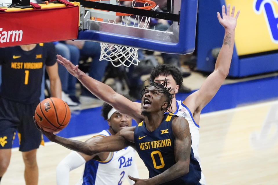 West Virginia's Kedrian Johnson (0) shoots as Pittsburgh's Nate Santos defends during the second half of an NCAA college basketball game, Friday, Nov. 11, 2022, in Pittsburgh. West Virginia won 81-56. (AP Photo/Keith Srakocic)