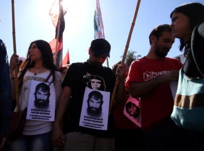 A man wearing a t-shirt with the image of Che Guevara and other protesters show portraits of Santiago Maldonado, a protester who has been missing since security forces clashed with indigenous activists in Patagonia on August 1, 2017, during a demonstration in Buenos Aires, Argentina October 19, 2017.  REUTERS/Marcos Brindicci