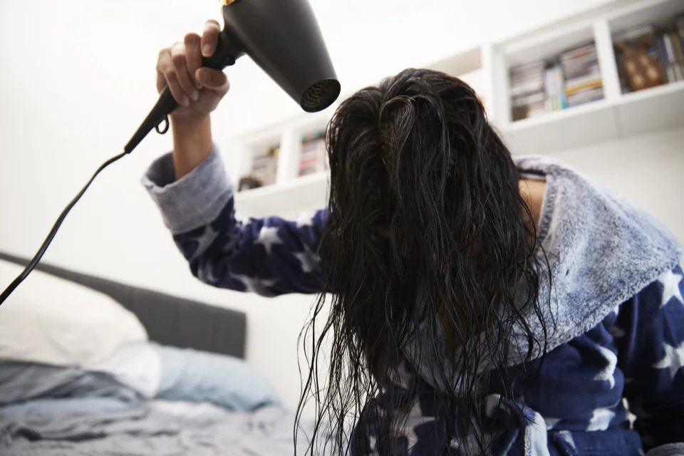 A woman drying her hair.