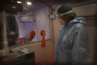 A health worker takes a break in between conducting COVID- 19 testing through rapid antigen methodology inside a mobile lab in New Delhi, India, Monday, Aug. 10, 2020. India is the third hardest-hit country by the pandemic in the world after the United States and Brazil. (AP Photo/Manish Swarup)