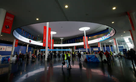 People walk past the main hall of the Mobile World Congress in Barcelona, Spain February 24, 2017. REUTERS/Albert Gea