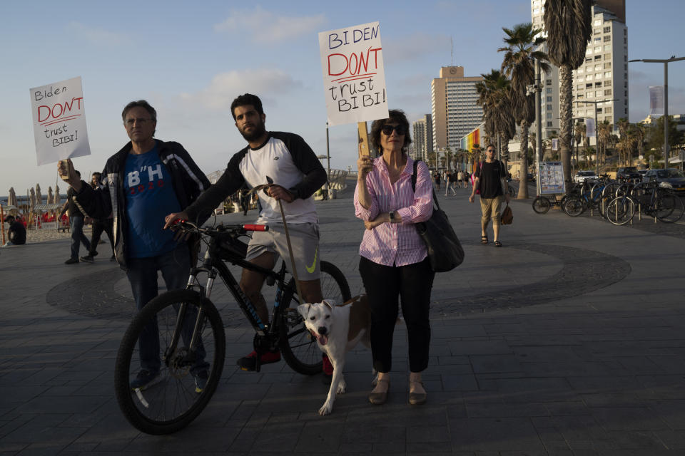 People hold up signs referring to the U.S. president Joe Biden to not trust in the Israeli Prime Minister Benjamin Netanyahu as they demonstrate demanding the end of the Israel-Hamas war with a regional peace agreement outside of the U.S. Embassy Branch Office in Tel Aviv, Monday, April 15, 2024. (AP Photo/Leo Correa)