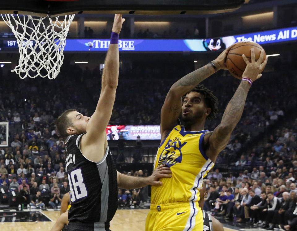 Golden State Warriors forward Marquese Chriss, right, goes to the basket against Sacramento Kings forward Nemanja Bjelica during the first quarter of an NBA basketball game in Sacramento, Calif., Monday, Jan. 6, 2020. (AP Photo/Rich Pedroncelli)